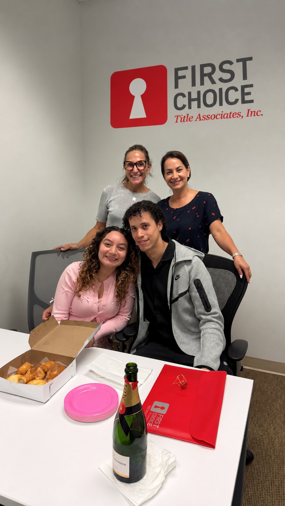 Isabel con clientes en su cierre, en la oficina de First Choice Title Associates en Miami.